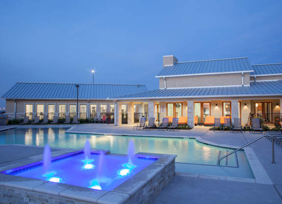 A pool with a fountain in the middle of it.