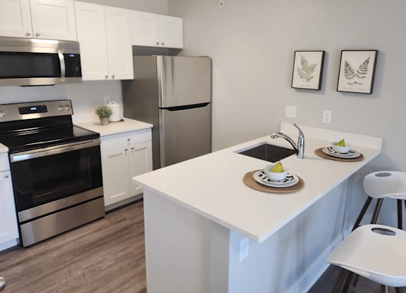 a kitchen with stainless steel appliances and a white counter top