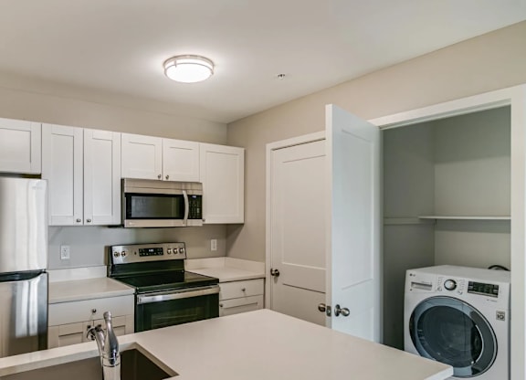 a kitchen with stainless steel appliances and white cabinets