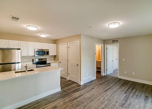 a kitchen with white cabinets and a sink and a refrigerator