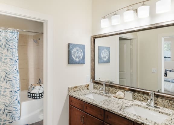 A bathroom with a patterned shower curtain and a large mirror.