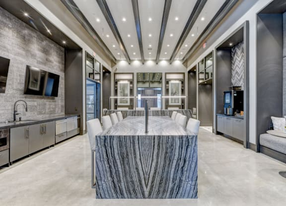 A modern kitchen with a marble table in the center.