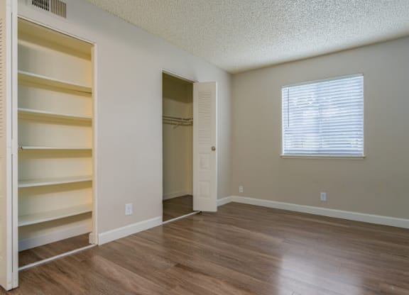 A room with a window and a door is empty and waiting to be furnished.