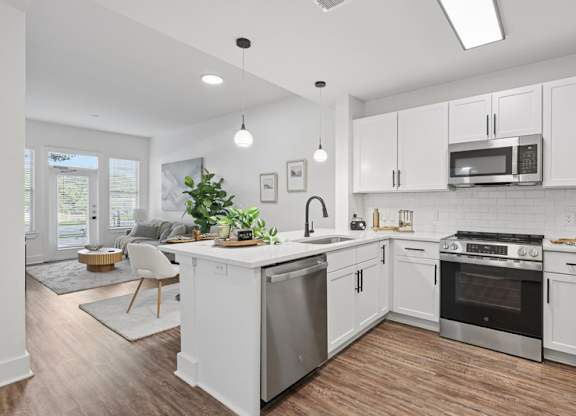 A modern kitchen with white cabinets and stainless steel appliances.