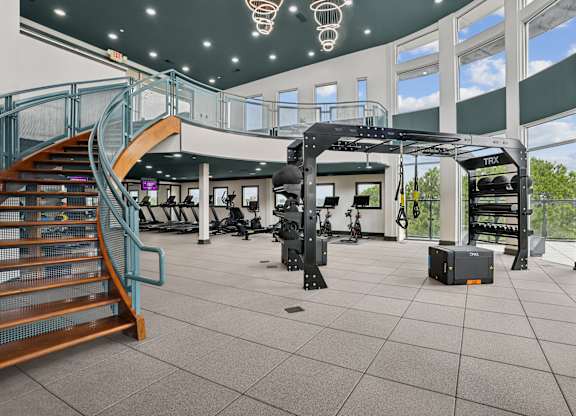 A gym with a staircase and exercise equipment.