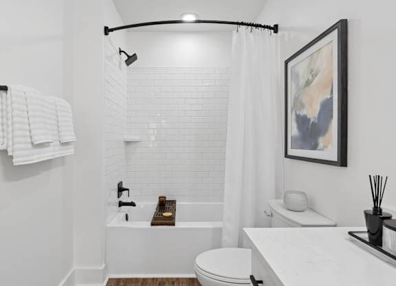A white bathroom with a toilet, sink, and bathtub.