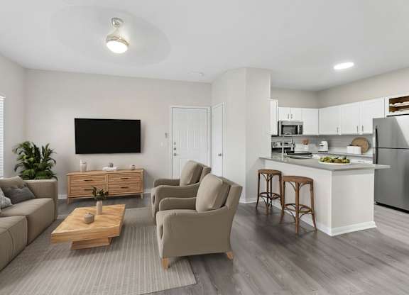 A modern living room with a grey sofa, a wooden coffee table, and a kitchen area in the background.