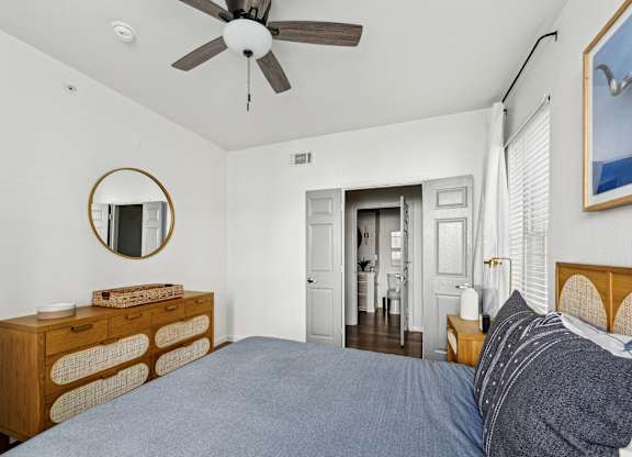 A bedroom with a bed, dresser, and mirror.
