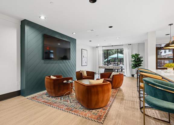 A living room with a green accent wall and a large mirror.