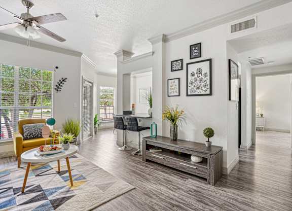 A living room with a yellow chair and a wooden coffee table.