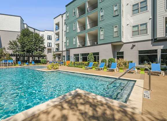 A swimming pool in front of apartment buildings.