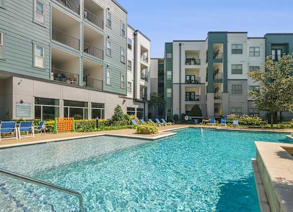 A swimming pool in front of apartment buildings.