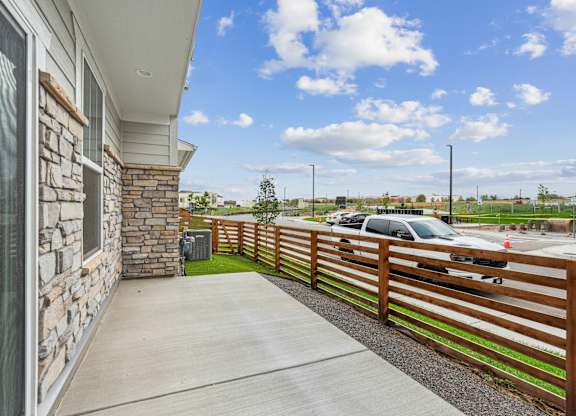 A house with a wooden fence and a car parked in the driveway.