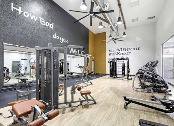 A gym with a variety of equipment including treadmills, weights, and exercise machines.