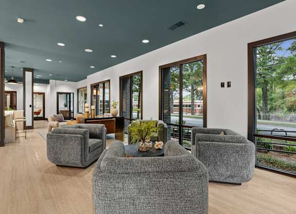 A modern living room with grey couches and a wooden coffee table.