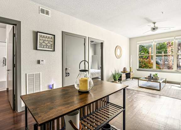 the dining room and living room of a house with a table and a large window