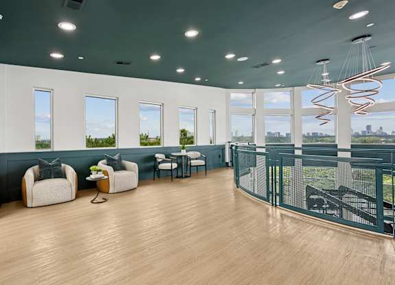 A room with a long table and chairs with a view of the city.