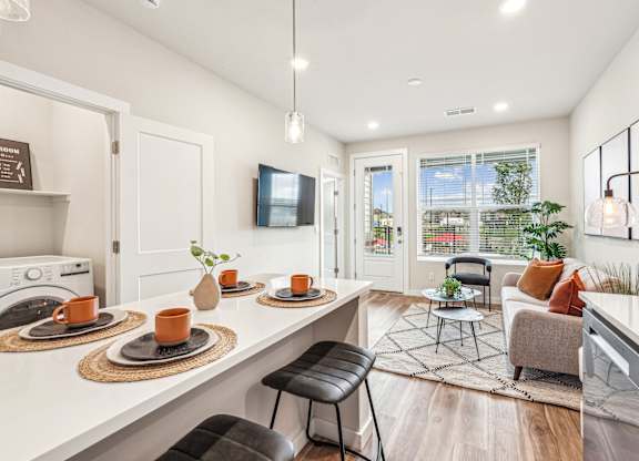 A modern kitchen with a dining area and a view of the backyard.