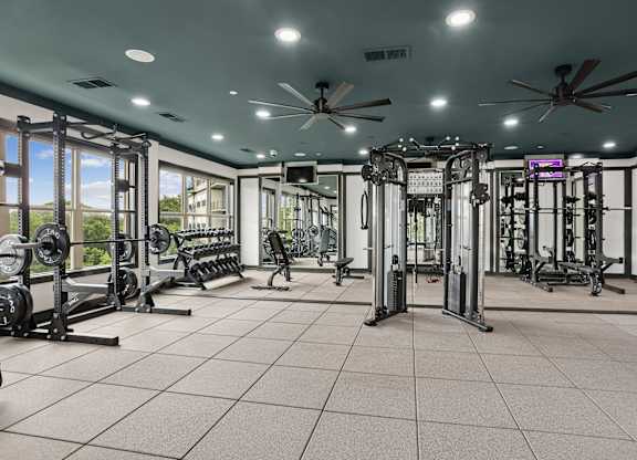 A spacious gym with a variety of equipment and a ceiling fan.