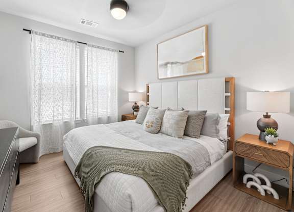 A bedroom with a large bed and a wooden nightstand.