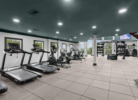 A gym with treadmills, exercise bikes, and other equipment.