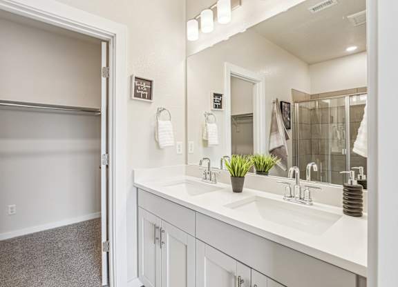 A bathroom with a white sink and a mirror.