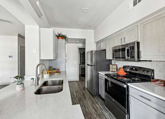 A kitchen with stainless steel appliances and white cabinets.