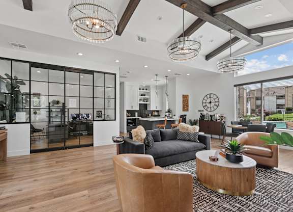 A modern living room with a glass wall and a wooden floor.