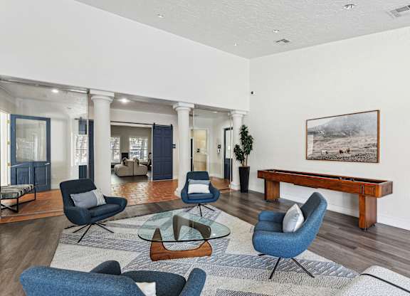 A living room with blue chairs and a wooden bench.
