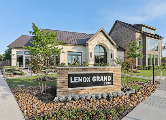 A sign in front of a building that says Lenox Grand.