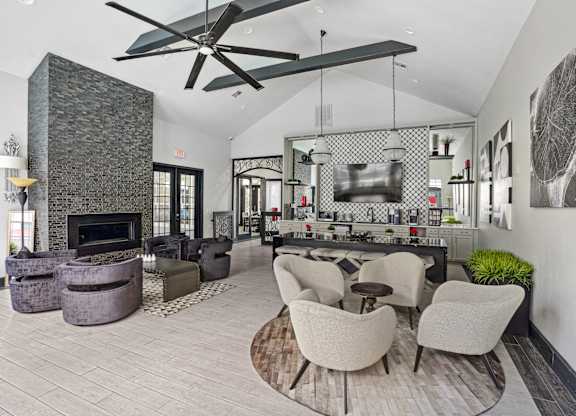 A modern living room with a stone fireplace and a large fan.