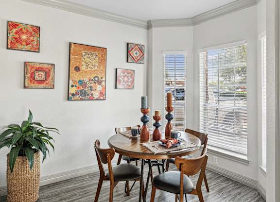 A dining room with a round table and chairs.