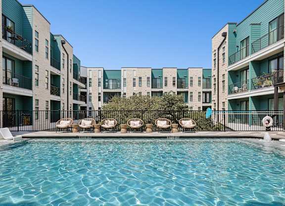 A swimming pool in front of apartment buildings.
