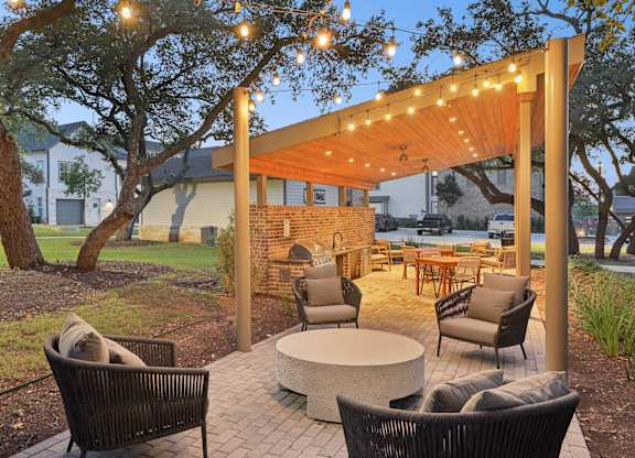 A patio with a table, chairs, and a fireplace.