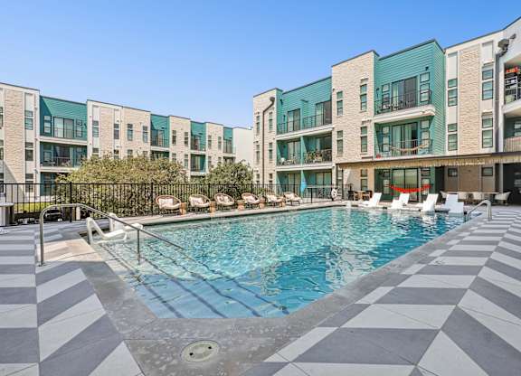 A swimming pool in front of a building with a black and white checkered floor.