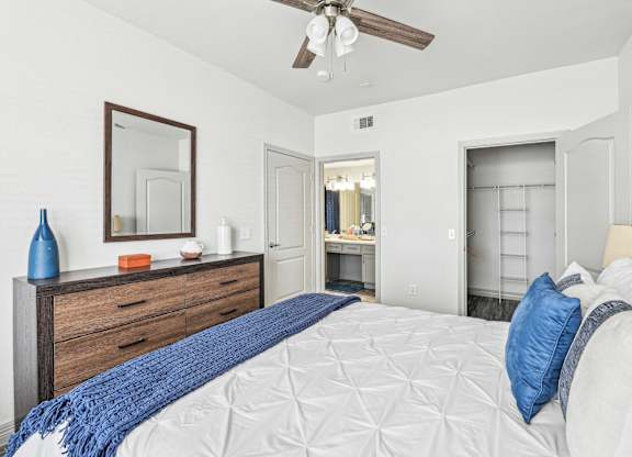 A bedroom with a large bed and a ceiling fan.