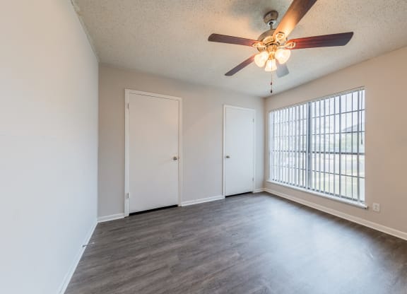 an empty living room with a ceiling fan