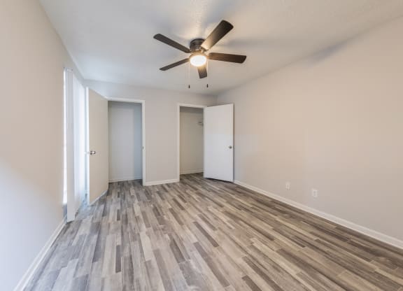 an empty living room with a ceiling fan