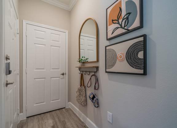a hallway with a white door and a mirror on the wall