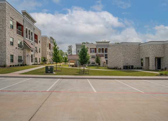 an empty parking lot in front of a brick building