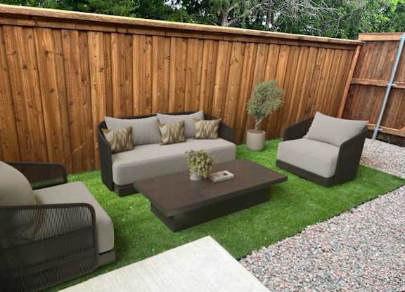 A patio with a couch, chairs, and a coffee table.