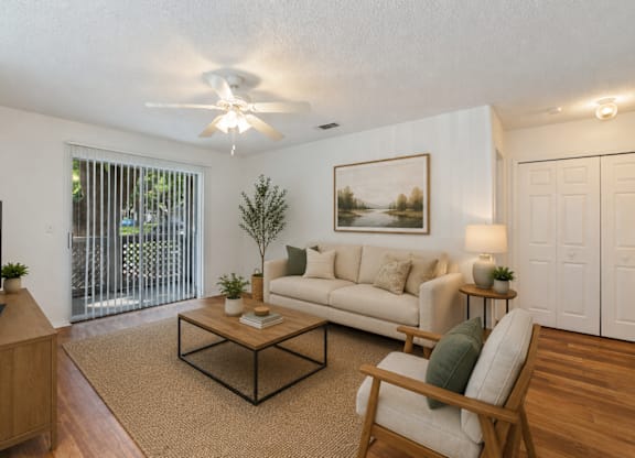 A living room with a couch, a chair, a coffee table, and a television.