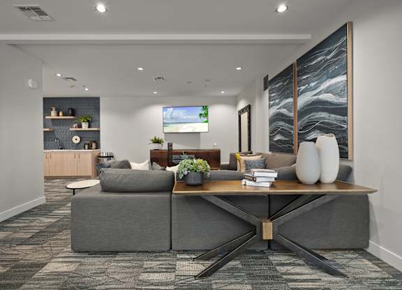 a living room with a gray couch and a wooden table