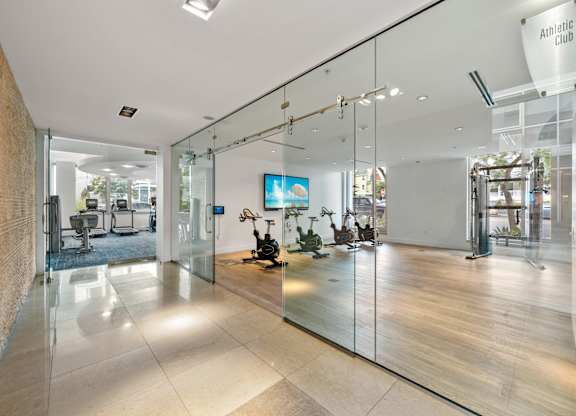 a large lobby with glass walls and a tv on the wall