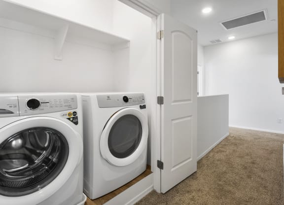 a washer and dryer in a laundry room with a white door