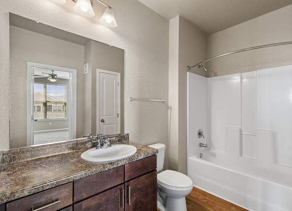 A bathroom with a sink, toilet, and bathtub.