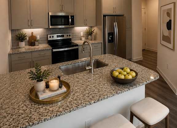 A kitchen with granite countertops and a bowl of lemons on it.