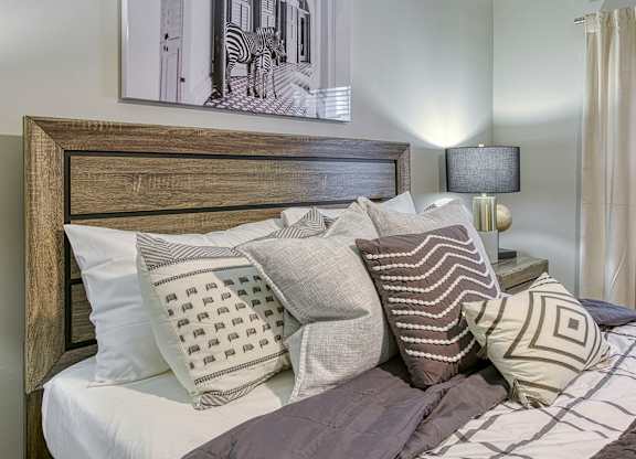 A bed with a wooden headboard and a painting of a zebra above it.