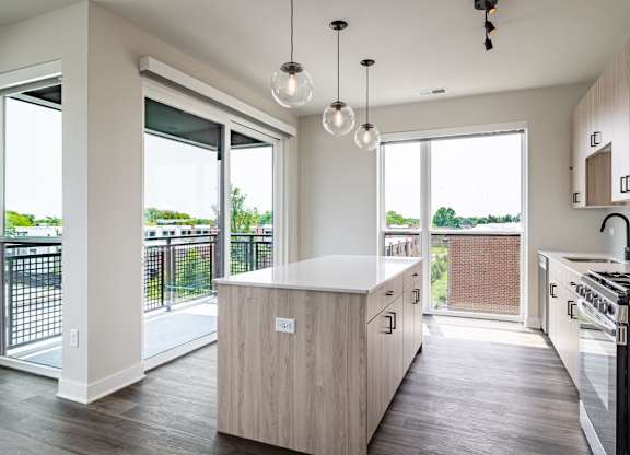 A modern kitchen with a wooden island and stainless steel appliances.