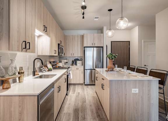 A modern kitchen with wooden cabinets and stainless steel appliances.
